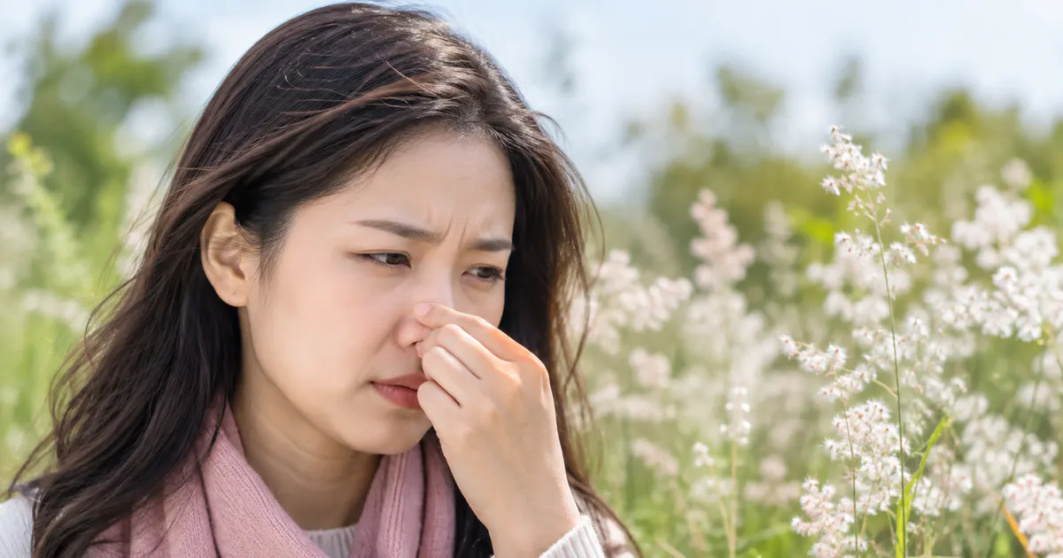 Người phụ nữ đeo khẩu trang ngoài trời trong mùa phấn hoa, minh họa viêm mũi dị ứng theo mùa