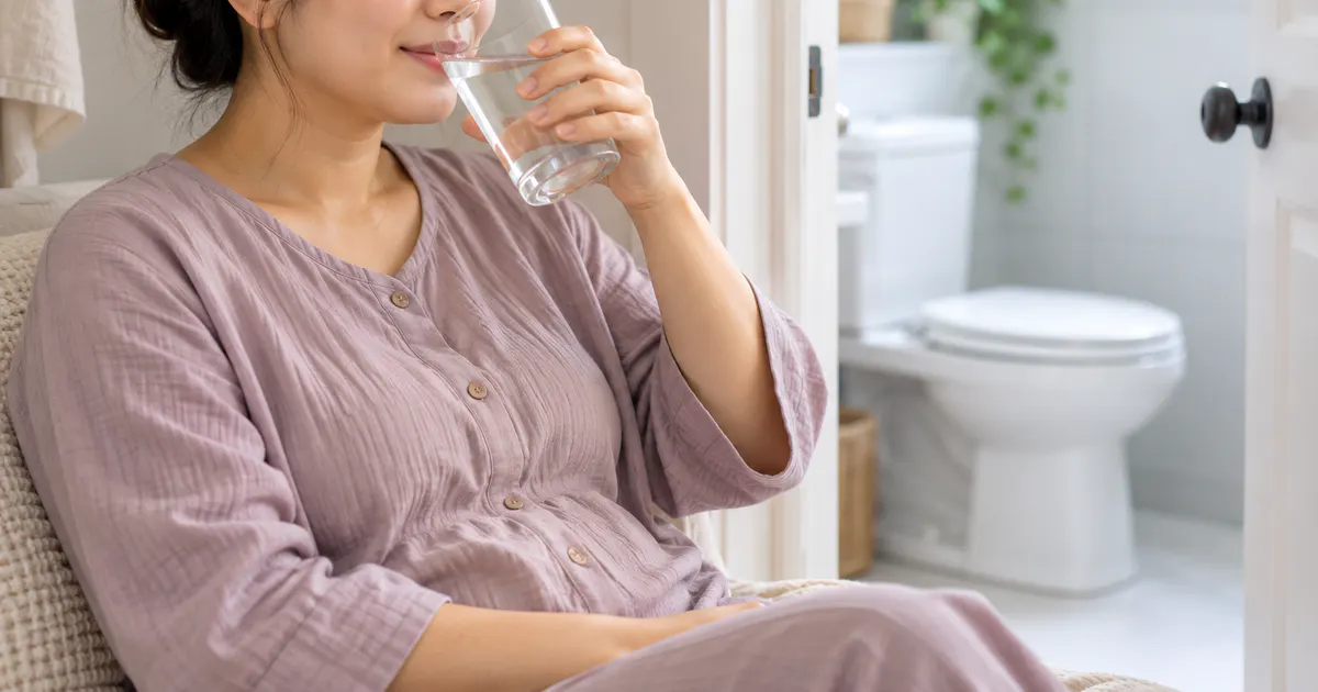 Mẹ sau sinh uống nước và chuẩn bị đi vệ sinh nhẹ nhàng, thoải mái