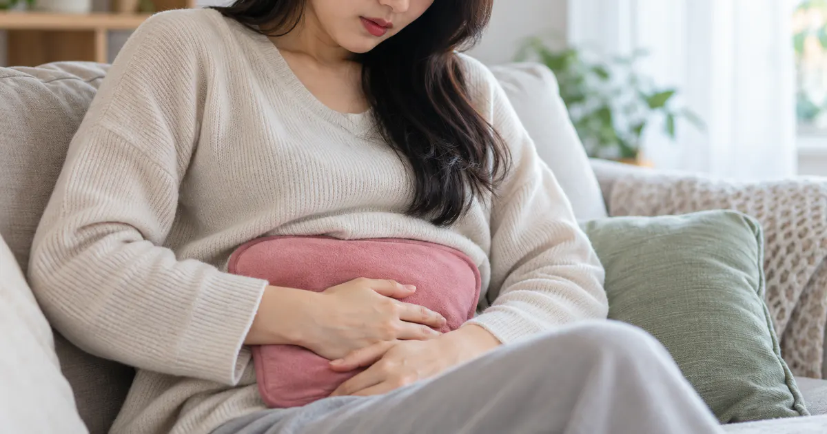 Đau bụng kinh dữ dội khi nào cần khám với người phụ nữ đang chườm ấm vùng bụng dưới