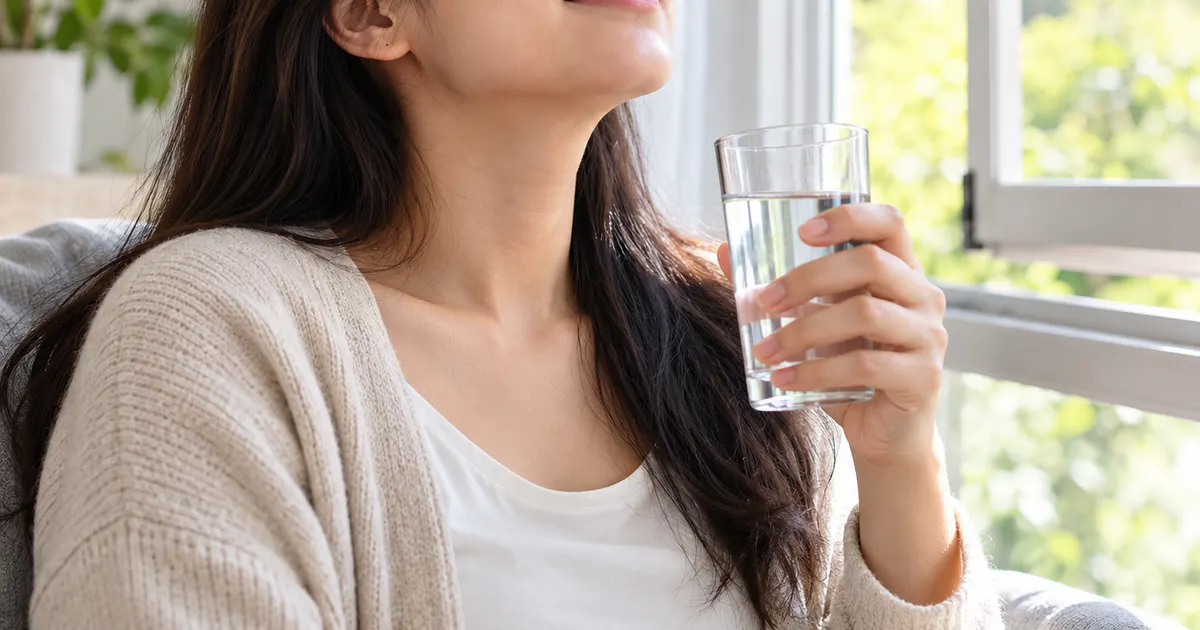 Người bệnh nghỉ ngơi và uống nước để hỗ trợ chăm sóc viêm xoang tại nhà