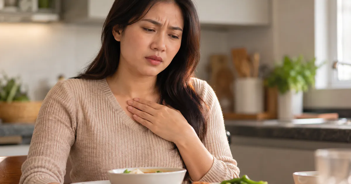Người phụ nữ kín đáo cảm nhận khó chịu do hiện tượng trào ngược dạ dày sau bữa ăn