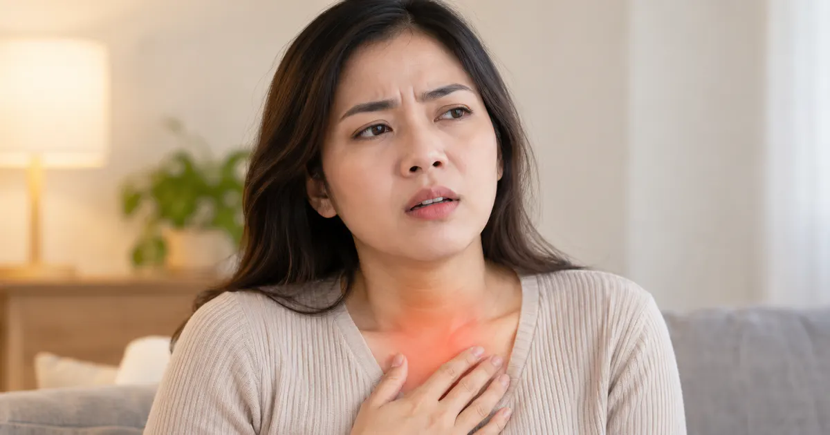 Người phụ nữ ngồi thẳng, ôm vùng ngực vì khó thở do trào ngược dạ dày
