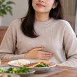 Người phụ nữ ăn tối nhẹ nhàng với tư thế phù hợp để chống trào ngược dạ dày