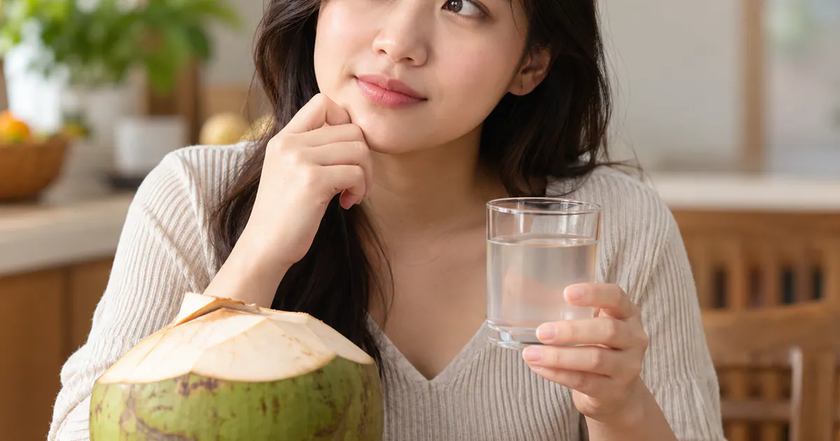 Trào ngược dạ dày có uống nước dừa được không với ly nước dừa tươi đặt cạnh bữa ăn nhẹ