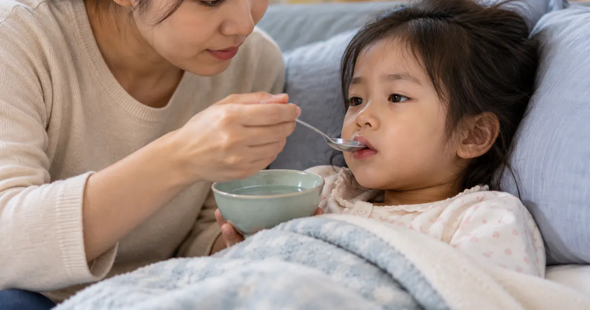 Người chăm sóc cho trẻ uống từng ngụm nhỏ khi trẻ đang mệt